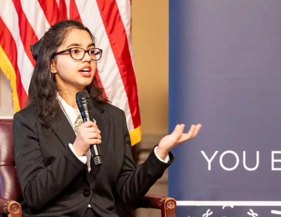 Sahiba Kaur speaking into a microphone at an event