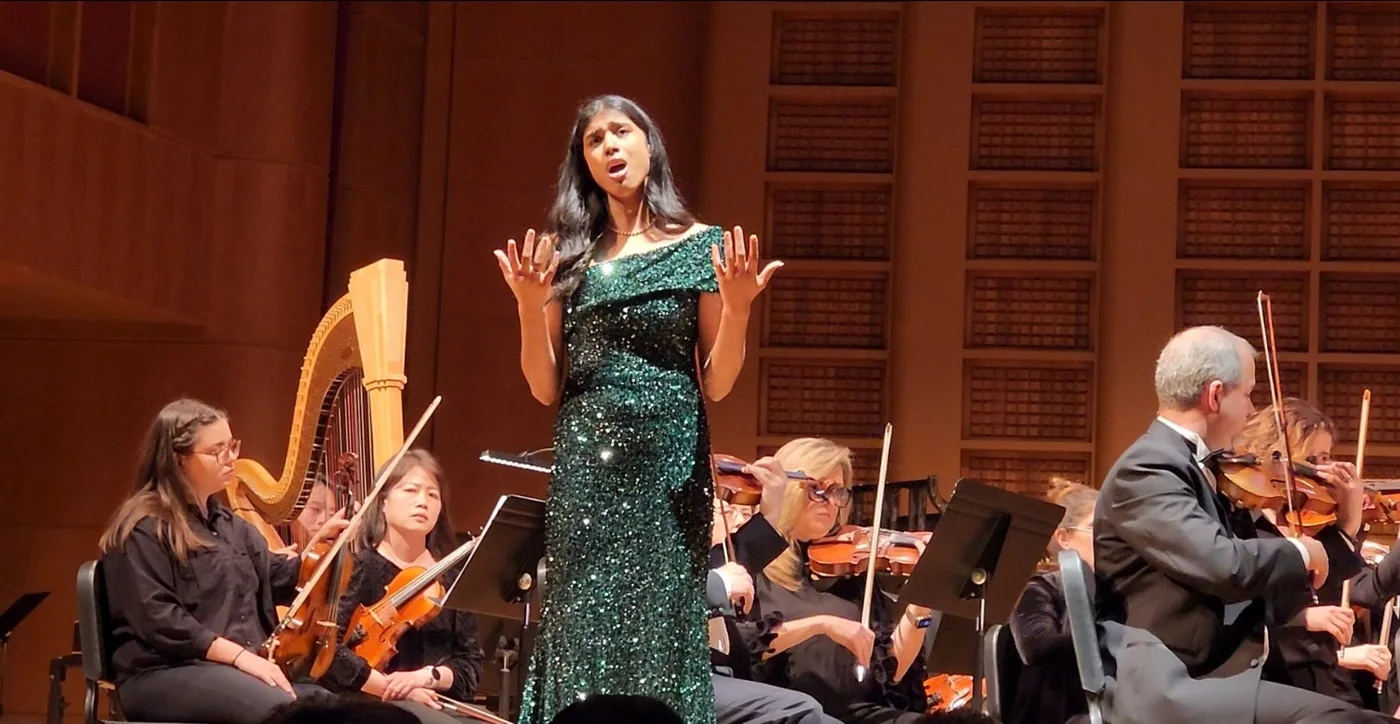 Tanya Mahesh singing with an orchestra